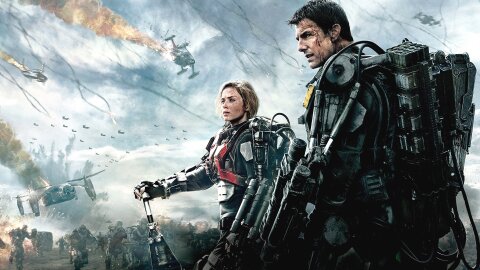 Tom Cruise and Emily Blunt standing badass in power armor before a scene of destruction